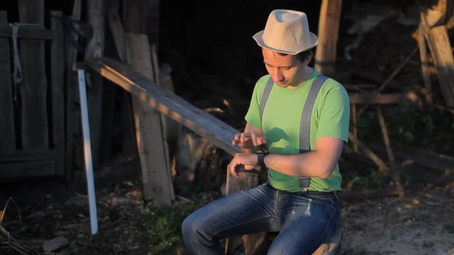 Man touching smart watches at the sawmill. sunset time