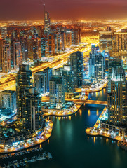 Fantastic rooftop skyline: illuminated architecture of a big city. Dubai Marina by night, United Arab Emirates.