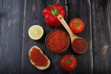 red and black caviar with bread on wooden background 