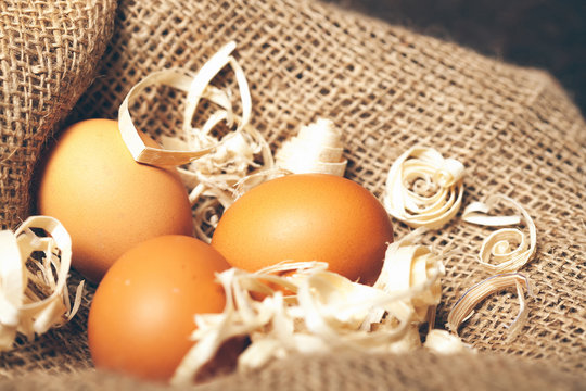 Three domestic eggs on sackcloth