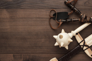 handmade wooden training toy sword, mace and slingshot on the table