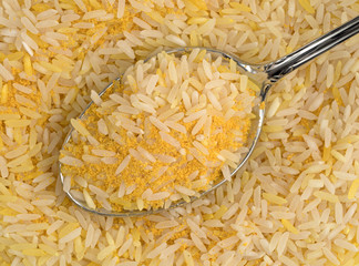 Saffron yellow rice on a spoon top view.
