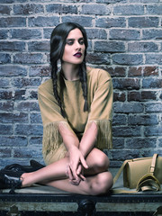Fototapeta na wymiar Elegant fashion model wearing mustard dress, sitting over chest.
