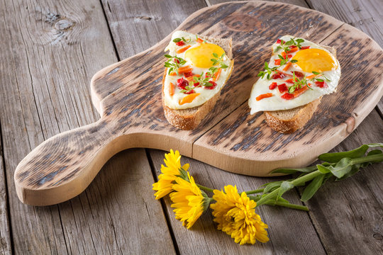 scrambled eggs with bread on cutting board