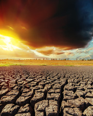 Fototapeta premium low dark clouds in sunset and drought earth closeup