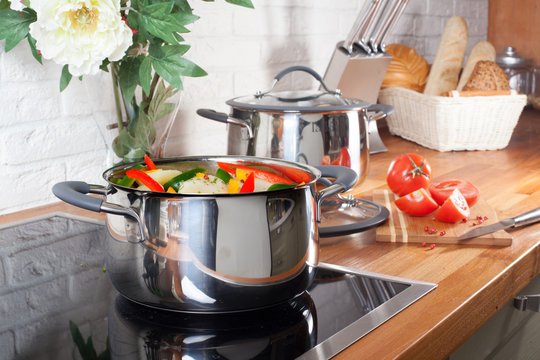 pan on the stove with vegetables in kitchen interior