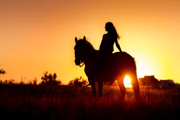 Fototapeten Beautiful silhuette of girl and horse at sunset  © callipso88
