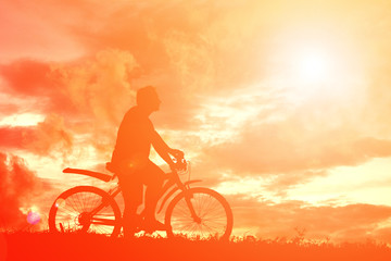 Fototapeta na wymiar Silhouette man with bicycle at sunset. relax time
