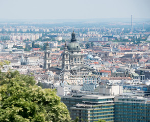 Obraz premium view of St. Stephens Basilica Big dome and Ferris wheel above rooftops in Budapest, Hungary, aerial photo