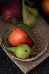 Organic pears and peaches on cloth closeup background, dark photography.
