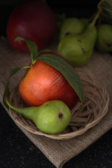 Organic pears and peaches on cloth closeup background, dark photography.