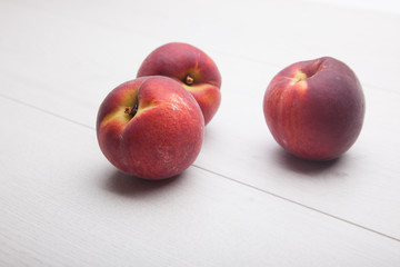 three peaches on white desk