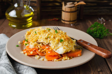 Oven-roasted fish fillet with carrots under a bread crust