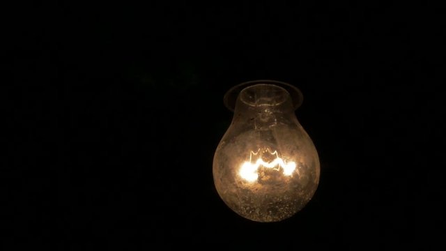 Slow motion dusty light bulb swings in the dark 1920X1080 HD video - Light bulb swinging horror scene 1080p FullHD slow-mo footage 