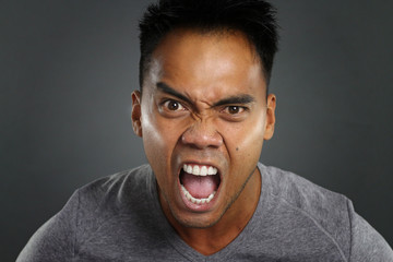 Young asian man screaming