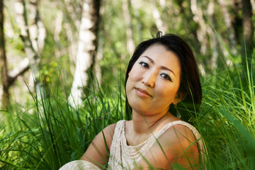 Asian woman portrait sitting in the grass