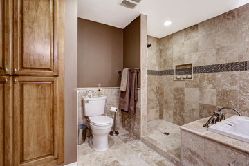 Naklejka na ściany i meble Empty bathroom interior. Light brown tile, bath tub and toilet