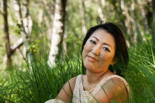 Asian woman portrait sitting in the grass