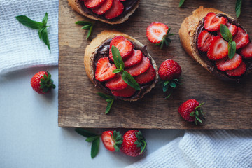 Strawberry bruschetta with chocolate paste and mint.Healthy thre