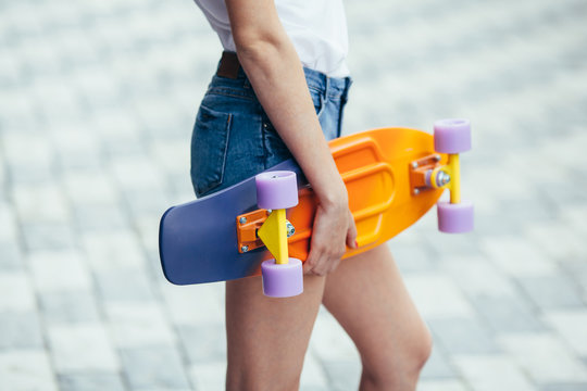 girl holding a skateboard,longboard, wearing casual shirt and je