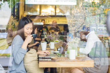 Beautiful smiling and young asian women drinking a coffee at cof