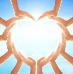 World environment day concept: Two Human hands show heart shape on blurred blue nature background