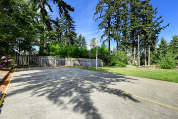 Basketball court with concrete floor and wooden fence