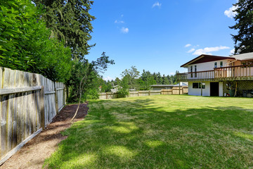 Fototapeta na wymiar Spacious backyard area with wooden fence