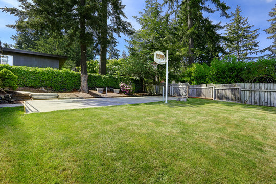 Basketball court with concrete floor and wooden fence