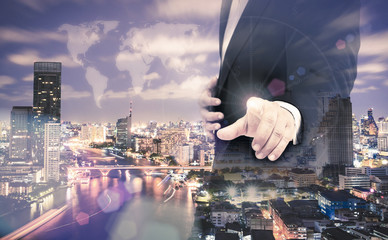 Real Estate Investment Trust concept: Double exposure businessman hand touching world map on futuristic communication interface and aerial view of Bangkok, Thailand along Chao Phraya River.