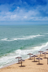 sea coast with thatched umbrellas