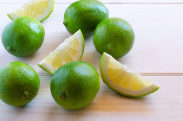 Fresh organic limes  with water drops on wooden background