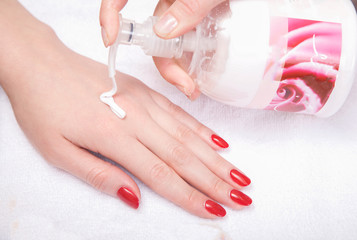 SPA treatment, hand massage and body care. beautiful female hand with red manicure close up.
