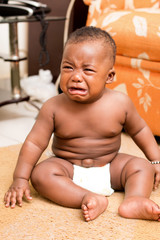 b&eacute;b&eacute; en pleure assis sur un tapis  