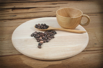 Coffee cup and coffee beans on wood board isolated