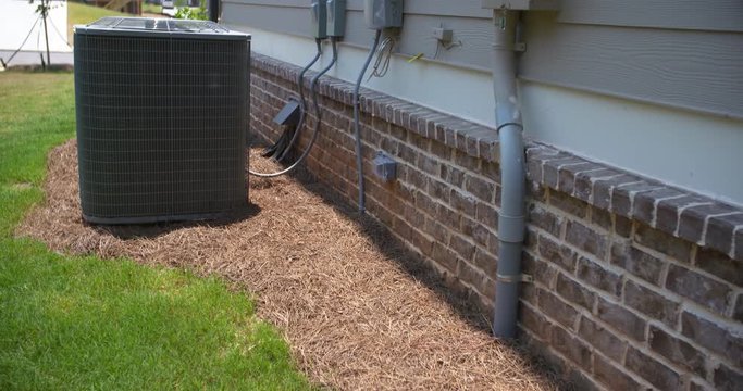 Air Conditioning Unit and Electric Meter Rise Side of Home slow rise on the side of a home showing the electric meter in the foreground and an central air conditioning unit in the background
