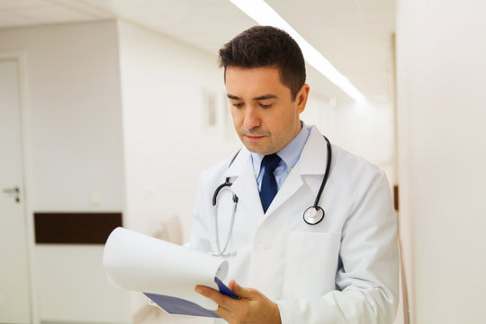 doctor writing to clipboard at hospital