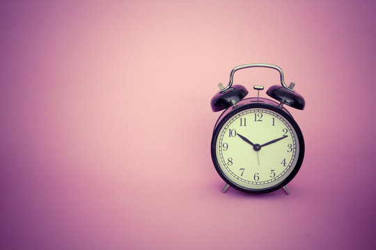 vintage alarm clock on pink background
