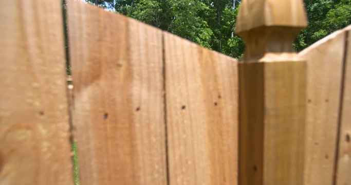 Rise Up to Reveal Backyard Fenced in. a close up of a new fence in the foreground rising up and over to reveal the entire backyard fenced in
