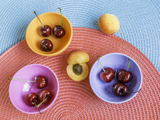 sweet cherries in colored bowls and apricot