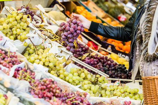 Frau kauft Obst auf Markt am Obststand