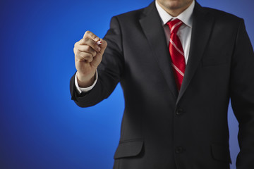 Businessman writing, drawing on the screen on a blue background