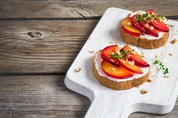 Summer breakfast bruschetta with plums,walnut and cottage cheese