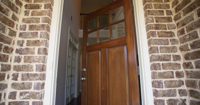 Front Home Entrance Low Angle Door Open Rise Up. rising low angle shot of the front entrance as the door opens to reveal the hallway of a modern residential home 
