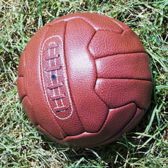 Vintage football over grass field