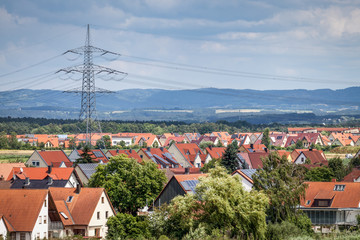 Riesiger Strommast Siedlungsgebiet Häuser Stromtrasse