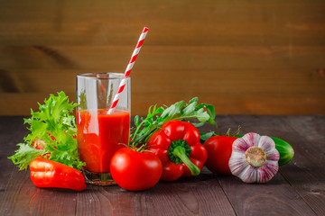 Red well being juice with vegetables on a wooden table