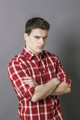 bored young sportsman with arms folded, looking depressed and irritated