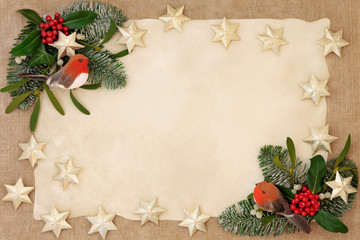 Christmas decorative background border with gold star and robin decorations, holly, ivy, mistletoe, snow covered  fir over old parchment and hemp paper.