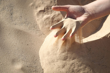 Sand slipping through fingers